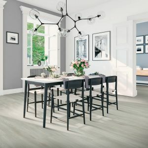 Laminate plank flooring in the dinning room area, with a large black seating table